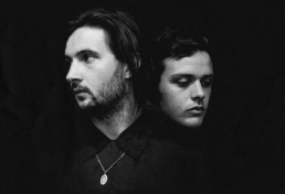 Graphic design services showcasing a minimalist black and white portrait album cover of two men in a dark space.
