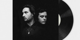 Graphic design services showcasing a minimalist black and white portrait album cover of two men in a dark space with vinyl.