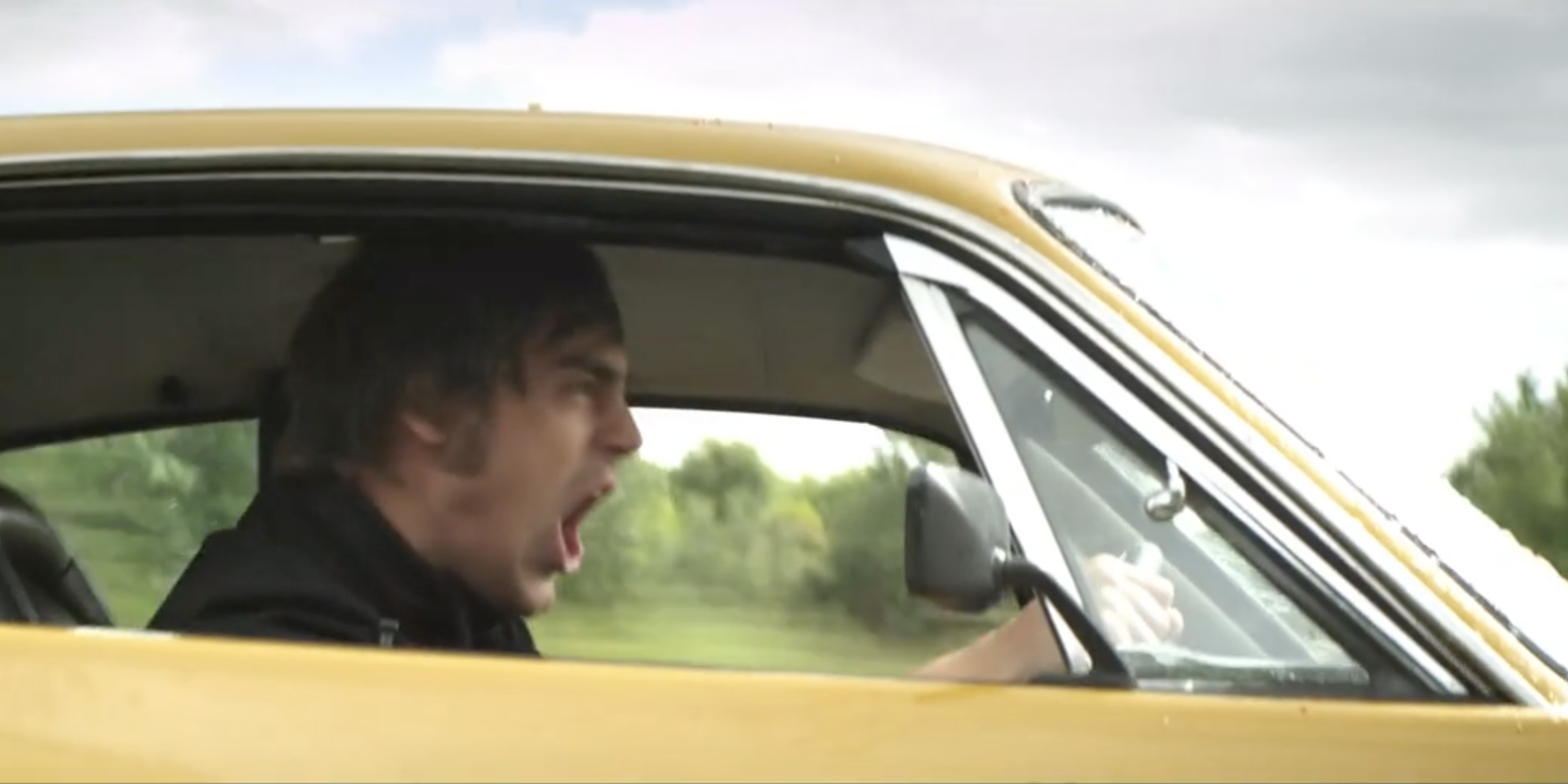 Man Driving Yellow American Muscle Car Aggressively Shouting