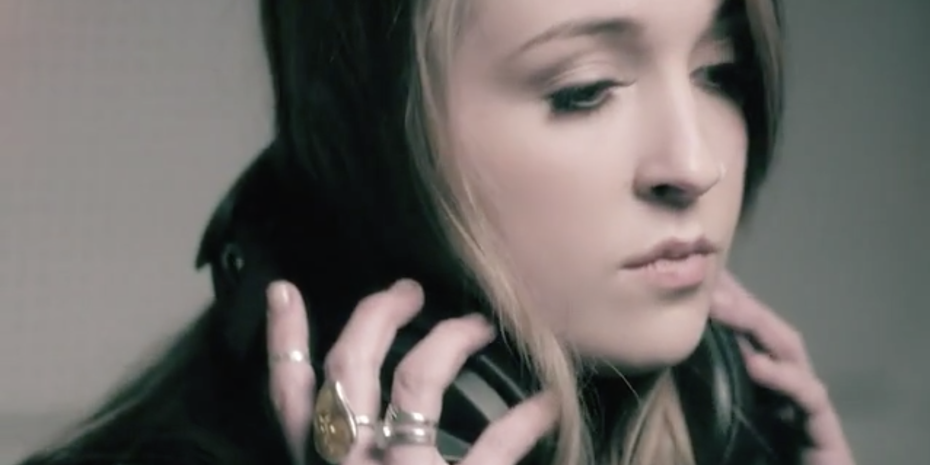 Singer Stands In Recording Booth Holding Headphones With Gemstone Rings