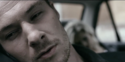 Cinematic music video production still featuring a dramatic narrative scene with a man in a classic BMW 3 Series.