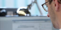 Corporate brand film production shot of a business professional sitting at a modern desk reviewing video marketing services.