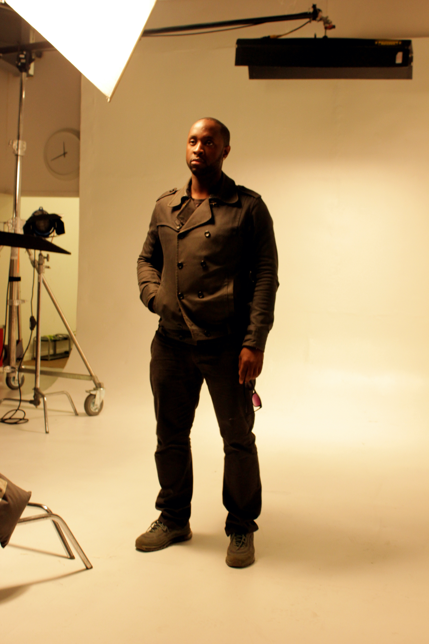 Professional Photography Closeup Of Black Man In Khaki Suite Standing On White Studio Backdrop With Lighting Stands