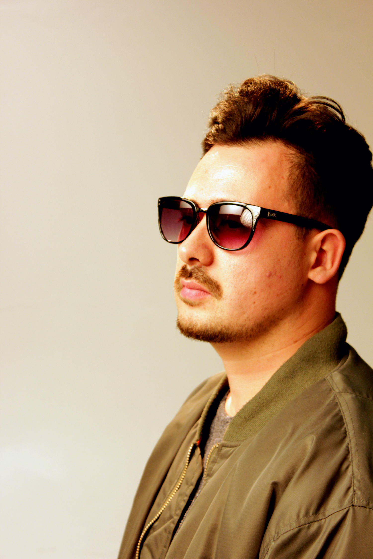 Professional Photography Close-Up Of White Man In Green Jacket And Moustache Standing On White Studio Backdrop