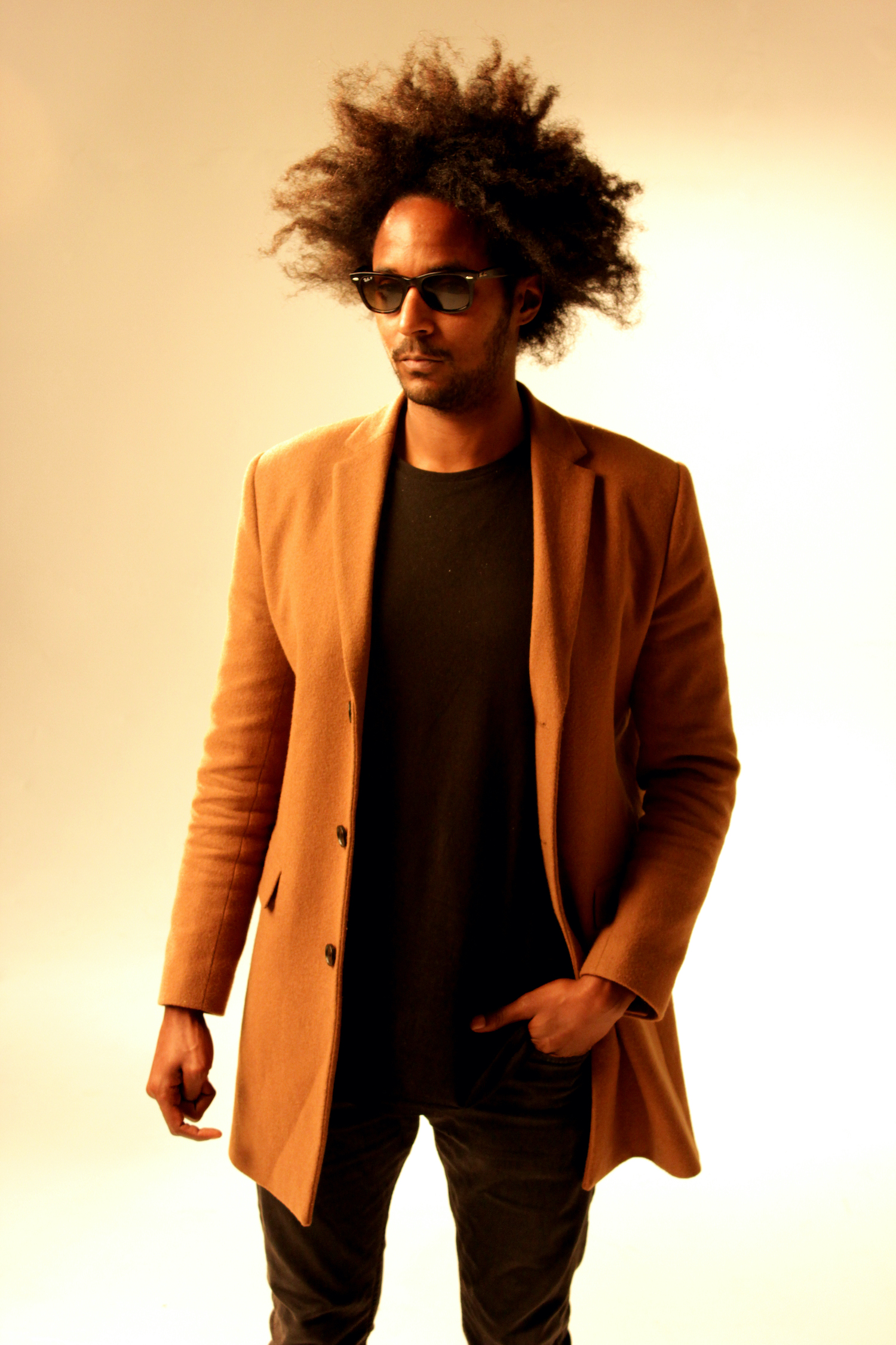 Professional Photography Black Man In Black Shirt Jeans Sunglasses And Orange Blazer Standing On White Studio Backdrop