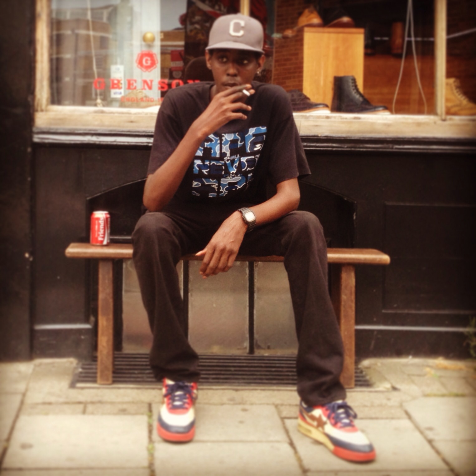 Professional Photography Black Man Sitting On Bench Sitting Outside Grenson Shoe Shop In Brick Lane London