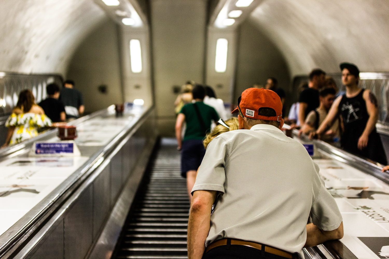 Professional Photography Old White Man With Orange Hat Ascending Escalators Inside Brixton Train Station South London