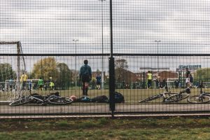 Professional lifestyle photography featuring retouching and colour correction of a goalkeeper on an urban football pitch.
