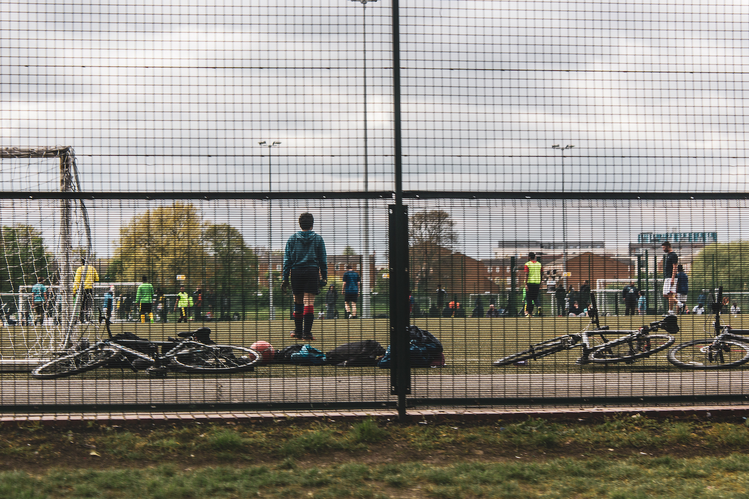 Professional Photography Male Goalkeeper Behind Fence On Football Pitch Playing A Game