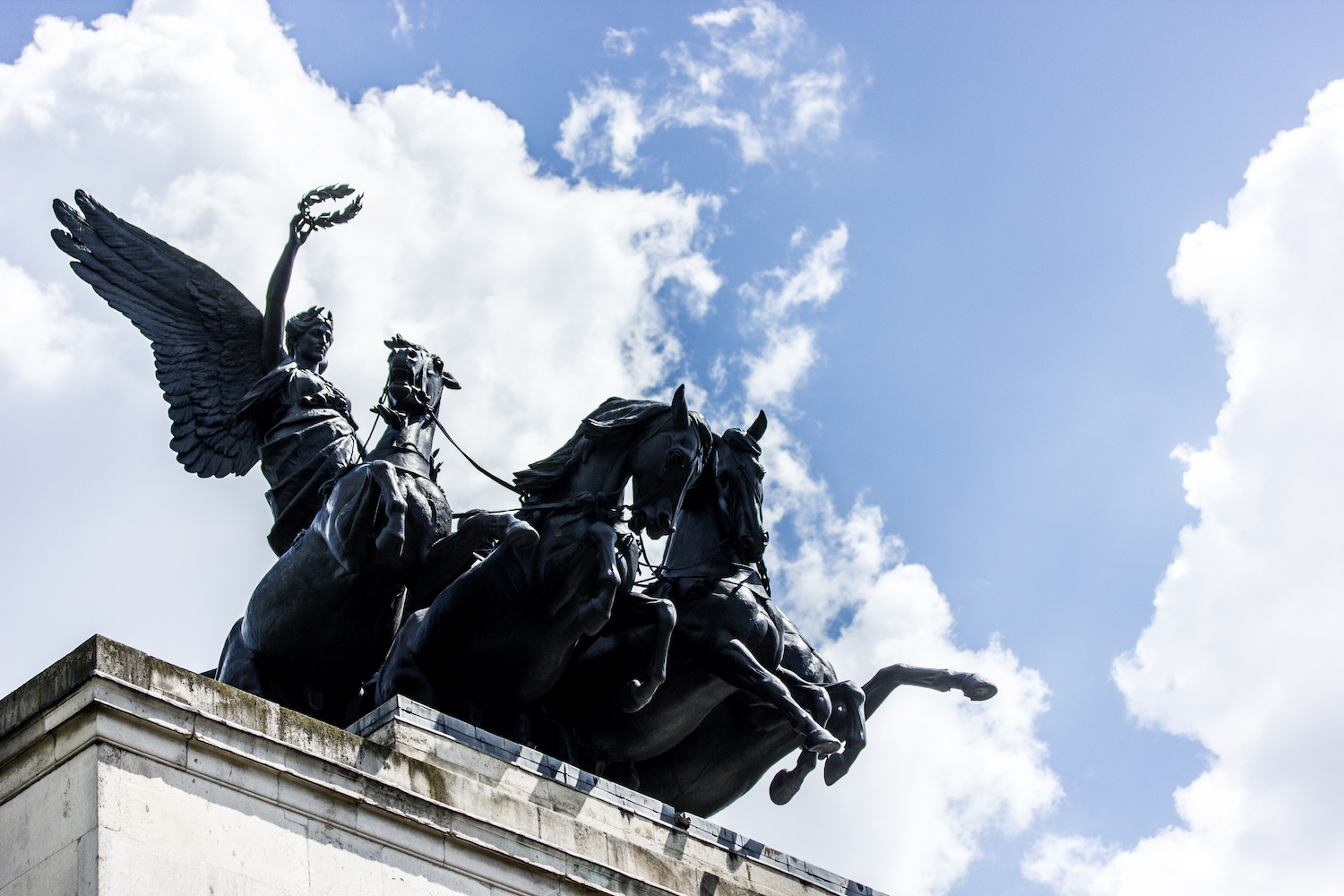 Professional Photography Black Statue Of Woman On Chariots With Three Horses On Top Of Arch With Blue Sky And Clouds At Hyde Park London