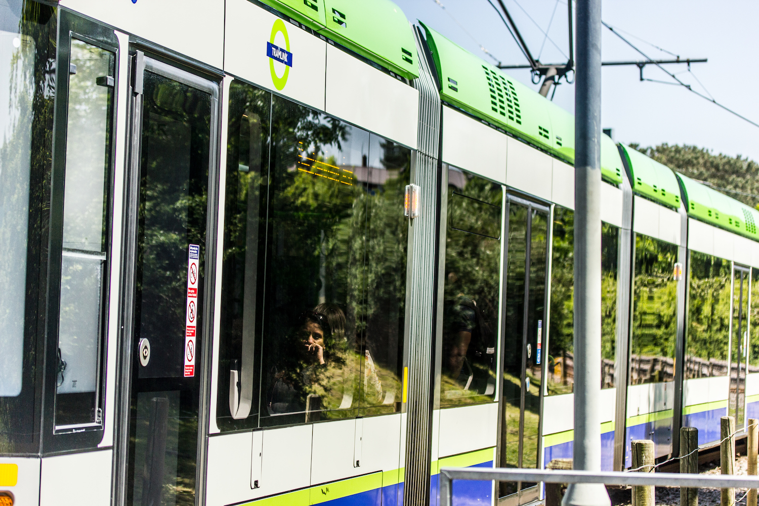 Professional Photography Asian Woman Sits On Green Tram Focussed Looking Out Of Window In South Norwood London