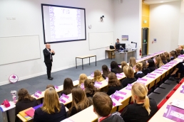 Professional Photography Man At Event Addressing Students In Lecture Theatre With Projector