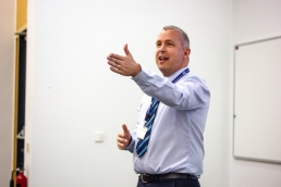 Professional Photography Man Wearing Lavender Colour Shirt And Blue Striped Tie Gesturing With Open Hand