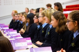 Professional Photography Female Students Wearing Navy Blue Sweatshirts Sitting In Row Watching Event
