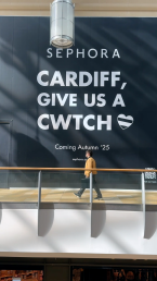a man walking past a Sephora coming soon sign in St Davids Dewi Sant, Cardiff