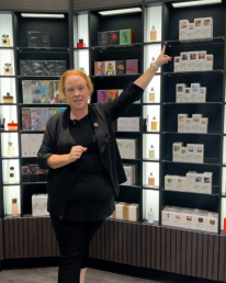 woman standing in The Fragrance Shop in Bluewater Kent, pointing at the perfume maison margiela and jimmy choo